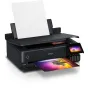 Epson EcoTank L8180 A3+ rašalinis spausdintuvas su Wi-Fi, EcoTank rašalo sistema ir bešalių nuotraukų spausdinimo galimybe, su iš dalies išspausdinta nuotrauka su medžiu prieš spalvingą saulėlydį ir tuščiu lapu išvesties dėkle.