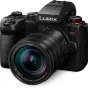 Panasonic LUMIX G9 II bešvitrinė kamera su Leica 12-60mm f/2.8-4.0 objektyvu, tekstūruota rankena, keliais valdymo diskai ir raudonu režimo mygtuku, pateikta prieš paprastą baltą foną.