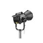 Godox MG1200Bi Bikolorių Knowled Light Kit 2 ant stovo, su juodu korpusu ir rankena, dideliu reguliuojamu reflektoriumi ir geltona maitinimo mygtuku, prijungtas prie valdiklio per kabelį, fone matoma minkšta dėžė ir reflektorių 