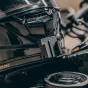 Falcam F22 greito atlaisvinimo klipas pritvirtintas prie blizgaus juodo šalmų paviršiaus, su paspaudimo mechanizmu ir pilkai-juoda apdaila, dalis veiksmų kamerų priedų komplekto.