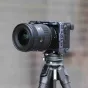 Falcam F22 & F38 Quick Release Camera Cage Sony A6700, sumontuotas ant anglies pluošto triko, demonstruojanti greito atlaisvinimo funkciją ir priedų tvirtinimo galimybes.