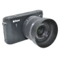 Nikon J1 kameros su pritvirtintu JJC HN-N101 saulės kapu, priekinis vaizdas, suderinamas su Nikon 10mm f/2.8 Solo objektyvu