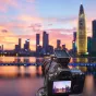 Godox X3Pro C 2.4G jutiklinis TTL siųstuvas ant Canon fotoaparato su miesto kontūru saulėlydžio fone
