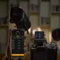 Godox X3Pro C 2.4G jutiklinis TTL siųstuvas, prijungtas prie Canon kameros, su apšvietimo grupių nustatymais ekrane, įkrovimo dėklu, USB-C laidu ir laikymo maišeliu