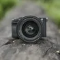 Viltrox AF 35mm F/1.2 LAB objektyvas su didele diafragma ir aukštos kokybės metaline konstrukcija ant natūralios medinės paviršiaus