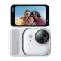 Insta360 Go Ultra veidrodinė aktyviosios nuotraukos kamera balta, su aktyviu displeju, rodančiu šeimos nuotrauką paplūdimyje, kompaktišku dizainu ir magnetiniu tvirtinimo elementu, matomas objektyvas ir viršus