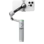 Insta360 Flow 2 Pro AI Tracker Bundle pilkoje spalvoje su prijungtu išmaniuoju telefonu, viršuje matomas magnetinis užsegimas ir išskleistas gimbal stabilizatorius