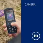 Panasonic KX-TF400EXC mėlynas kompaktiškas mobilusis telefonas su kamera, rodančiu gėlių nuotrauką 2.4 colio ekrane, natūralioje aplinkoje