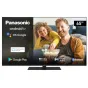 Panasonic 65 colų Android televizorius TX-65LX650E, rodantis gyvenimo sceną su pora, mėgaujančia popkornu, su Android TV, OK Google, įmontuotu Chromecast, Google Play, Dolby Vision Atmos, žaidimų režimu ir Bluetooth jaukioje sve