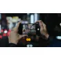 Tilta Khronos iPhone 16 Pro rankinis rinkinys su fokusavimo rankena ir filtro dėže, naudojamas nakties miesto peizažo filmavimui mobiliajame kine