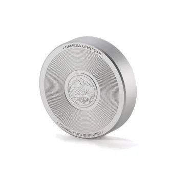 Tilta sidabrinis objektyvo dangtelis Fujifilm X100VI/X100V su koncentrinėmis linijomis ir išgraviruotu logotipu su kalnų peizažu. Tilta sidabrinis objektyvo dangtelis Fujifilm X100VI/X100V su koncentrinėmis linijomis ir išgraviruotu logotipu su kalnų peizažu.