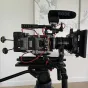 Vaxis STORM 3000 TX bežiedinis vaizdo transliuotojas su Rode mikrofonu, rodomas priekis su OLED ekranu, 3G-SDI ir HDMI įvestimis, dviejų RP-SMA antenų jungtys ir 1080p60 nekompresuoto vaizdo transliavimo galimybė iki 900 metrų