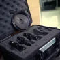 Vaxis VFX 114mm dioptrių komplektas su keturiais pažymėtais elementais apsauginiame dėžutėje, padėtas lauke šalia pastato.