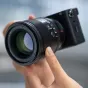 Viltrox AF 56mm f/1.2 E greitas portreto objektyvas Sony E-Mount su aštria optika ir nuostabiu boke, rodomas artimas nuotrauka su pritvirtintu objektyvo gaubtu ir kameros korpusu