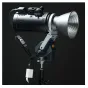 Falcam Move LightGo AC galios adapteris prijungtas prie Move LightGo LED šviestuvo, su AC įėjimo kabeliu ir USB-C jungtimi, sumontuotas ant trikampio tipo rankos, su LED šviestuvo galva pasukta į priekį, rodant jos priekinį grot