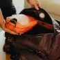 Peak Design Packing Cube Small ibis spalvos atvira dėžutė viduje Peak Design krepšyje, rodanti du skyrius ir suspaudimo dizainą