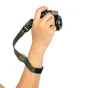 Peak Design Cuff rankos juosta kelp žalios spalvos, tvirtai pritvirtinta prie DSLR kameros, su reguliuojamu magnetiniu užraktu, patogiam nešiojimui kaip apyrankė ar rankos juosta.