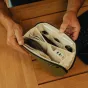 Peak Design Tech Pouch Small kelp spalvos su atviru vaizdu, demonstruojančiu organizuotą 12 skydečių vidų su kabeliais, atminties kortelėmis ir USB įrenginiu.