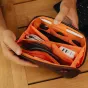 Peak Design Tech Pouch Small eclipse spalvos su organizuotais techniniais priedais: kabeliais, USB atmintimi ir ausinėmis viduje.