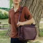 Peak Design Everyday Tote V2 15L bordo spalvos krepšys su magnetiniu užtrauktuku, rodantis paminkštintą petinę juostą ir atvirą vidinę organizaciją parko aplinkoje