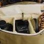 Peak Design Everyday Backpack Zip V2 20L jūros žolės spalvos, su DSLR kamera ir objektyvu viduje, rodantis FlexFold skirstiklius ir minkštus skyrius pritaikytai organizacijai.