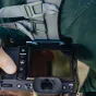 Peak Design Capture Clip V3 vandenyno spalvos pritvirtintas prie fotoaparato juostos su greitu paleidimo mygtuku, skirtas greitai objektyvų keitimui ir saugiam nešiojimui