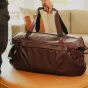 Peak Design Travel Duffel 65L su amortizuotomis viršutinėmis rankenomis, pagaminta iš tvirto 600D perdirbto nailono ir su vandeniui atspariu dugnu, skirtu kelionėms ir įrangos saugojimui