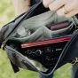 Peak Design Outdoor Sling 4L juodas krūtinės maišas su fotoaparato objektyvu, saulės akinių ir organizuotomis kišenėmis nuotykių reikmenims.