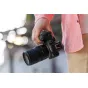 Tamron 17-70mm F2.8 Di III-A VC RXD objektyvas Canon RF APS-C kameroms, laikomas vertikalioje padėtyje, rodantis priekį ir objektyvo gaubtą.