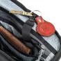 Raudonas odinis raktų pakabukas su įgraviruotu tekstu ir kabeliniu užraktu ant Think Tank Airport Essentials Rolling Backpack