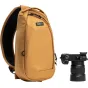 Think Tank TurnStyle 5L Golden Hour siksnos krepšys su juodu tinkleliu gale, dviem užtrauktukais uždaromais skyreliais, saugiu priekinio kišeniu ir kameros tvirtinimo bėgiu, šalia yra Sony Alpha DSLR su 24-70mm objektyvu.