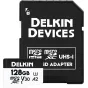 Delkin 128 GB microSDXC UHS‑I V30 kortelė su pilno dydžio SD adapteriu, rodoma prieš juodą apsauginę dėžutę.