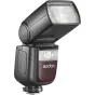 Godox Speedlite V860III Nikon blykstė, sumontuota ant kameros karštosios pėdos, šiek tiek pakreipta į viršų, matomas priekinis difuzorius. Blykstė turi juodą korpusą su raudonu akcentu, ant kurio matomas 'Godox' logotipas, įjung
