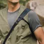 PGYTECH Camera Strap Pro Midnight Black su ergonomine 60 mm peties pagalve, greito atjungimo sagtimi ir reguliuojamu ilgiu, dėvimas ant krūtinės modelio lauko aplinkoje.