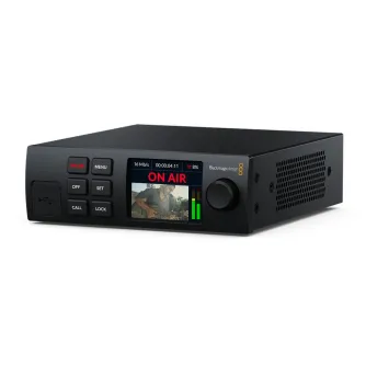 Blackmagic Streaming Encoder HD su skaitmeniniu ekranu, kuriame rodomas 'ON AIR', vaizdo peržiūra su gitaristu ir žali garso lygio matuokliai. Valdymo mygtukai apima 'ON AIR', 'MENU', 'OFF', 'SET', 'CALL', 'LOCK' ir USB prievadą