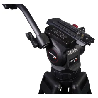 Artimas vaizdas Cartoni FOCUS 8 trikojos galvutės su raudonu užrakinimo mechanizmu, prijungtos prie 2 pakopų aliuminio trikojos. Ypatybės apima 'FOCUS 8' logotipą, 'CARTONI' prekės ženklą, reguliuojamus mygtukus ir raudoną užrak