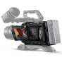 Artimas vaizdas į Blackmagic URSA Mini Pro 12K OLPF kamerą ant trikojų, su 4 colių LCD jutikliniu ekranu, rodančiu tiesioginį vaizdą, dideliu objektyvu su 29 mm fokusavimo atstumu, viršutiniu rankenėle ir akumuliatoriaus laikikl