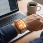 Tech-Protect Nylon Pro laikrodžio dirželis Huawei Watch Fit 3/4/4 Pro/5/5 Pro starlight, kvėpuojantis tekstilinis diržas ant riešo su nešiojamuoju kompiuteriu ir kavos puodeliu modernioje darbo vietoje.