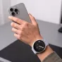 Tech‑Protect periwinkle pintas nailono dirželis Samsung Galaxy Watch 40/44/46mm, reguliuojamas ir kvėpuojantis, dėvimas ant rankos laikant išmanųjį telefoną.