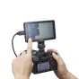 Godox GM6S Pro 4K Ultra Bright 5,5" kameros monitorius, prijungtas prie be veidrodinės kameros, rodantis tiesioginį vaizdą ir meniu, su prijungtu HDMI kabeliu, pabrėžiantis jo 2000 nitų ryškų jutiklinį ekraną ir profesionalias v