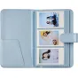 Mėlyna Fujifilm Instax Mini 13 foto albūmu su sintetinėmis kėrėmis, atidarytas, kad ištatytų trīs 54×86 mm instant foto ant 36 puslapių.
